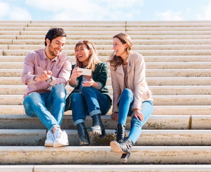 drei Menschen sitzen auf einer Treppe